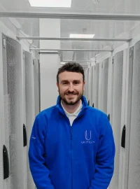 UK1tech team member in front of servers